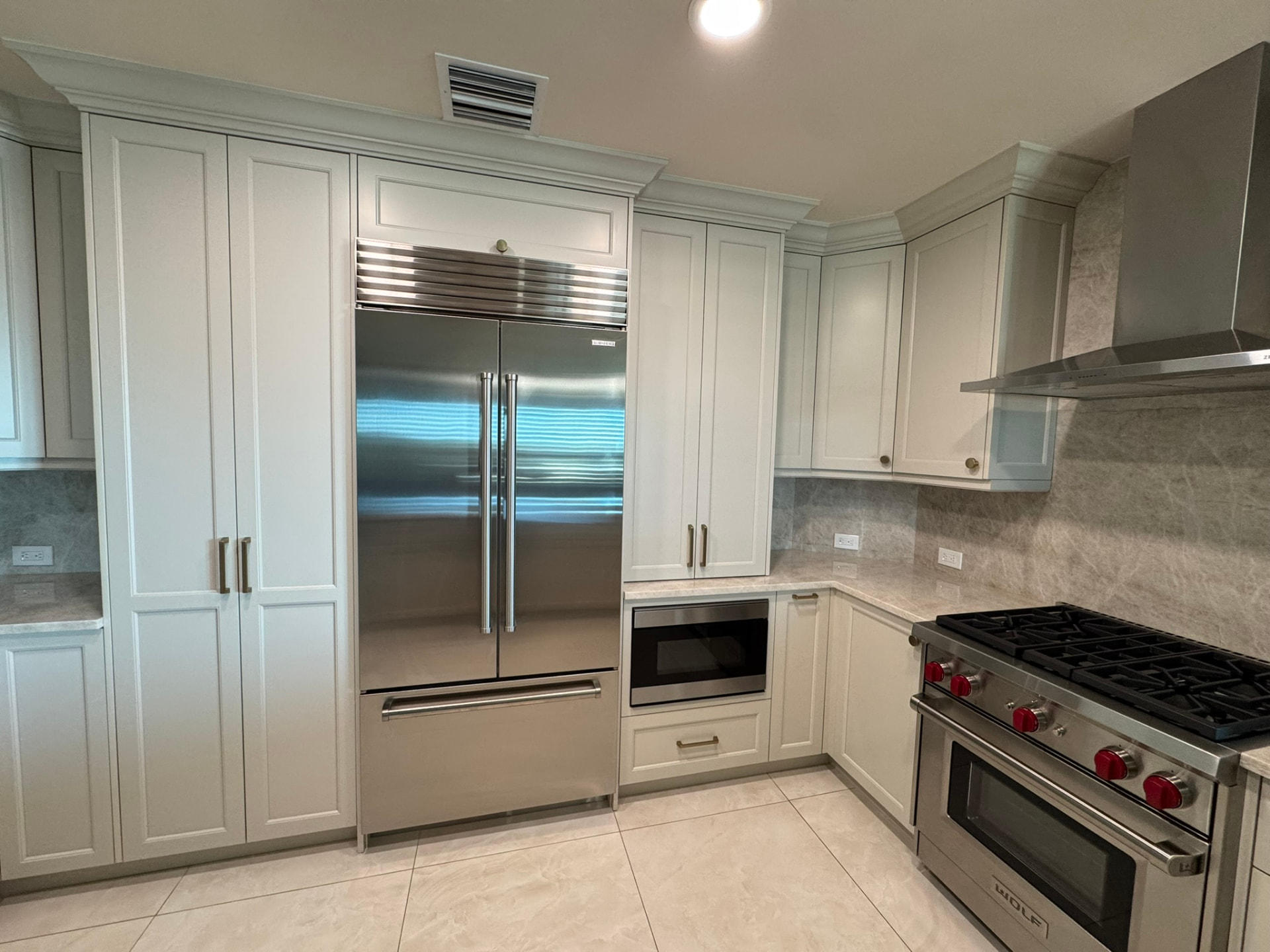 Painted inset kitchen cabinetry with tall pantry storage and built-in microwave cabinet