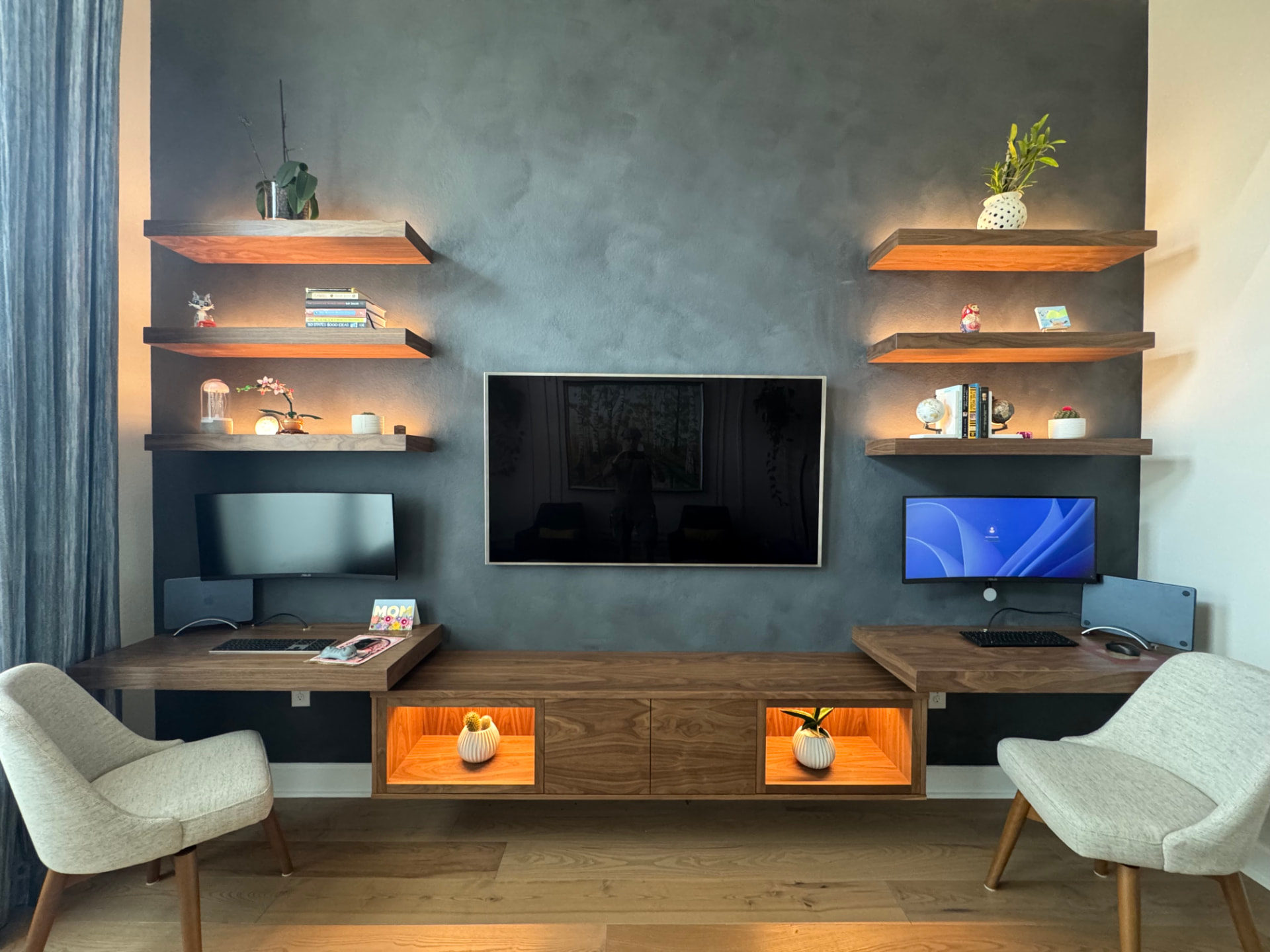Floating walnut console and desks against a dark accent wall