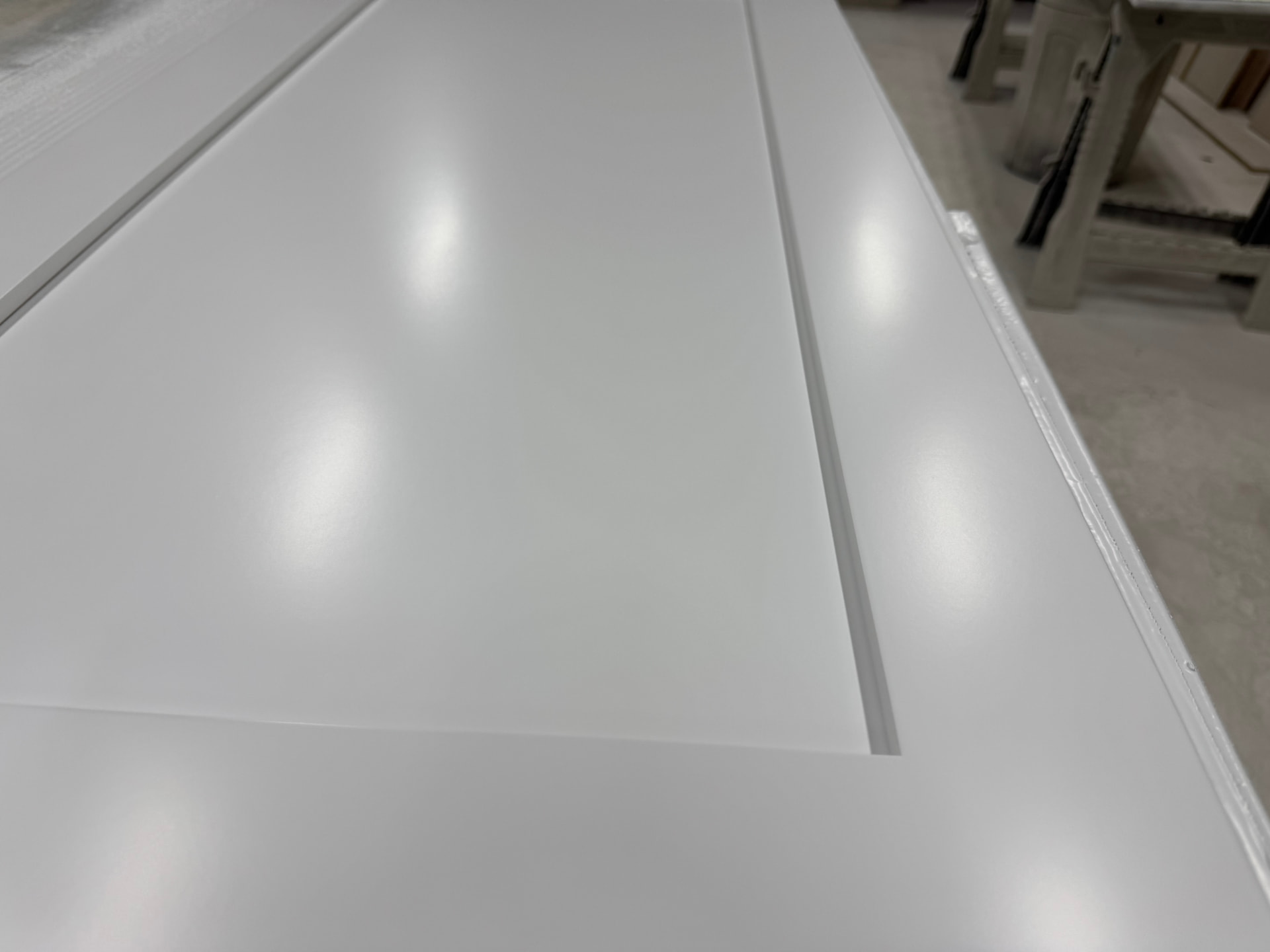 Close-up of a smooth sprayed white cabinet door showing an even, level finish