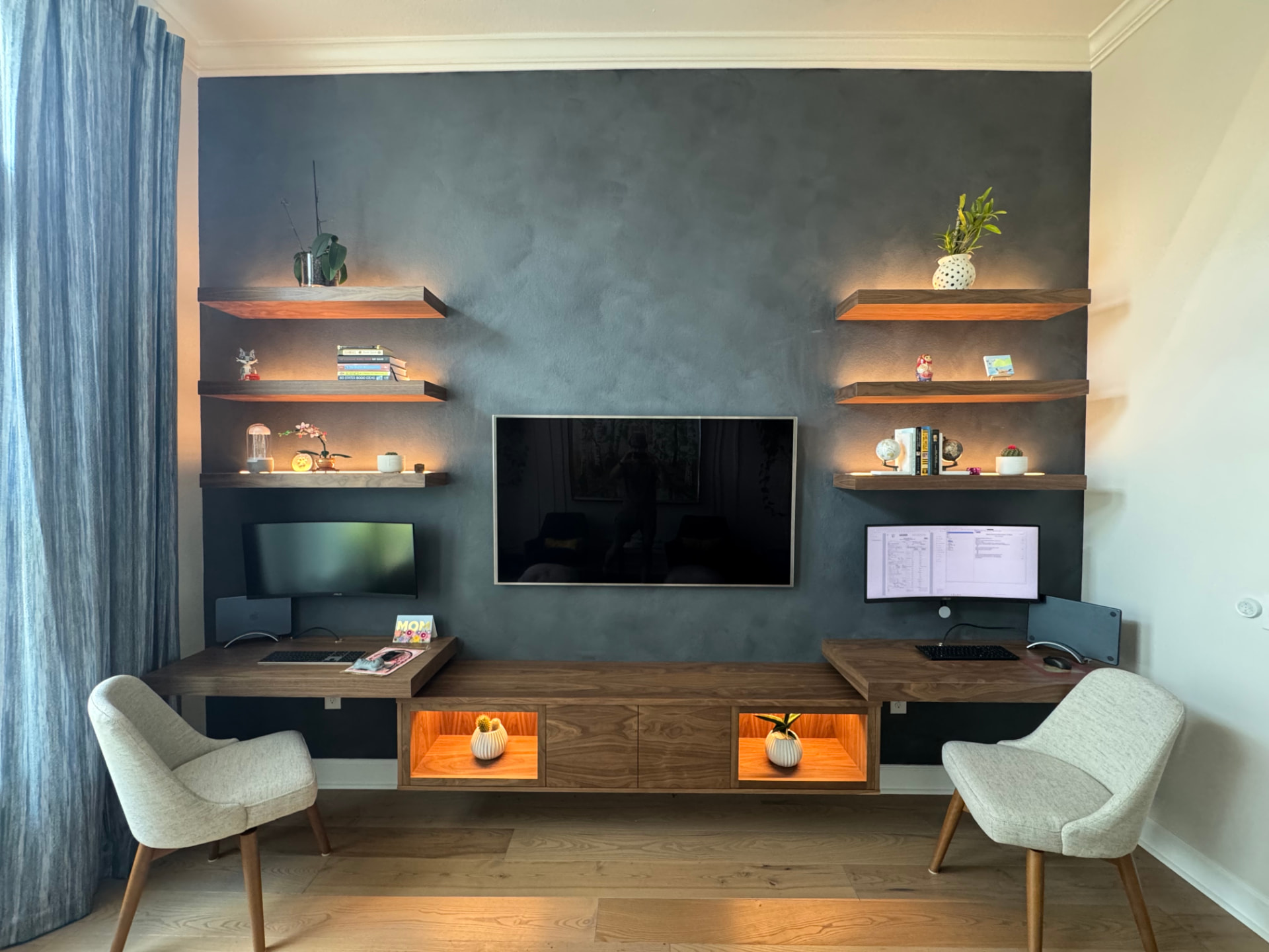 Custom floating walnut entertainment center with dual built-in desks and LED-lit floating shelves