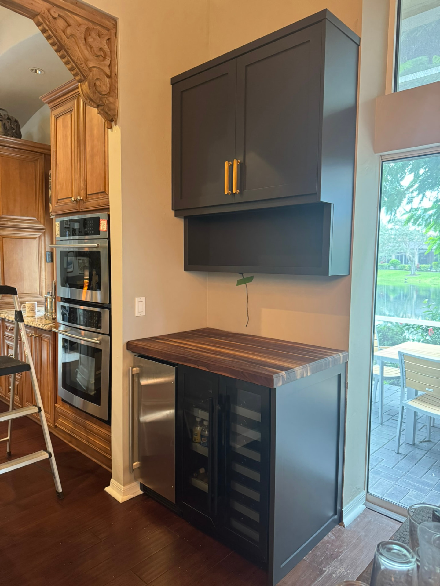 Custom charcoal painted beverage bar with walnut butcher-block top and wine cooler