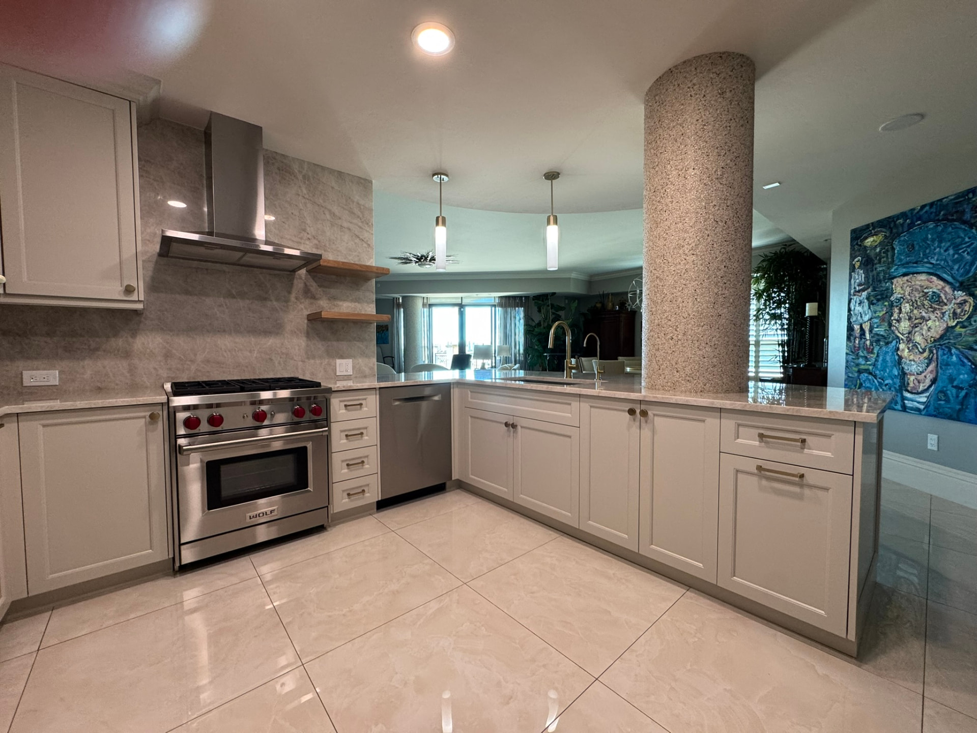 Open-plan condo kitchen with painted base cabinetry, range wall shelving, and quartzite counters