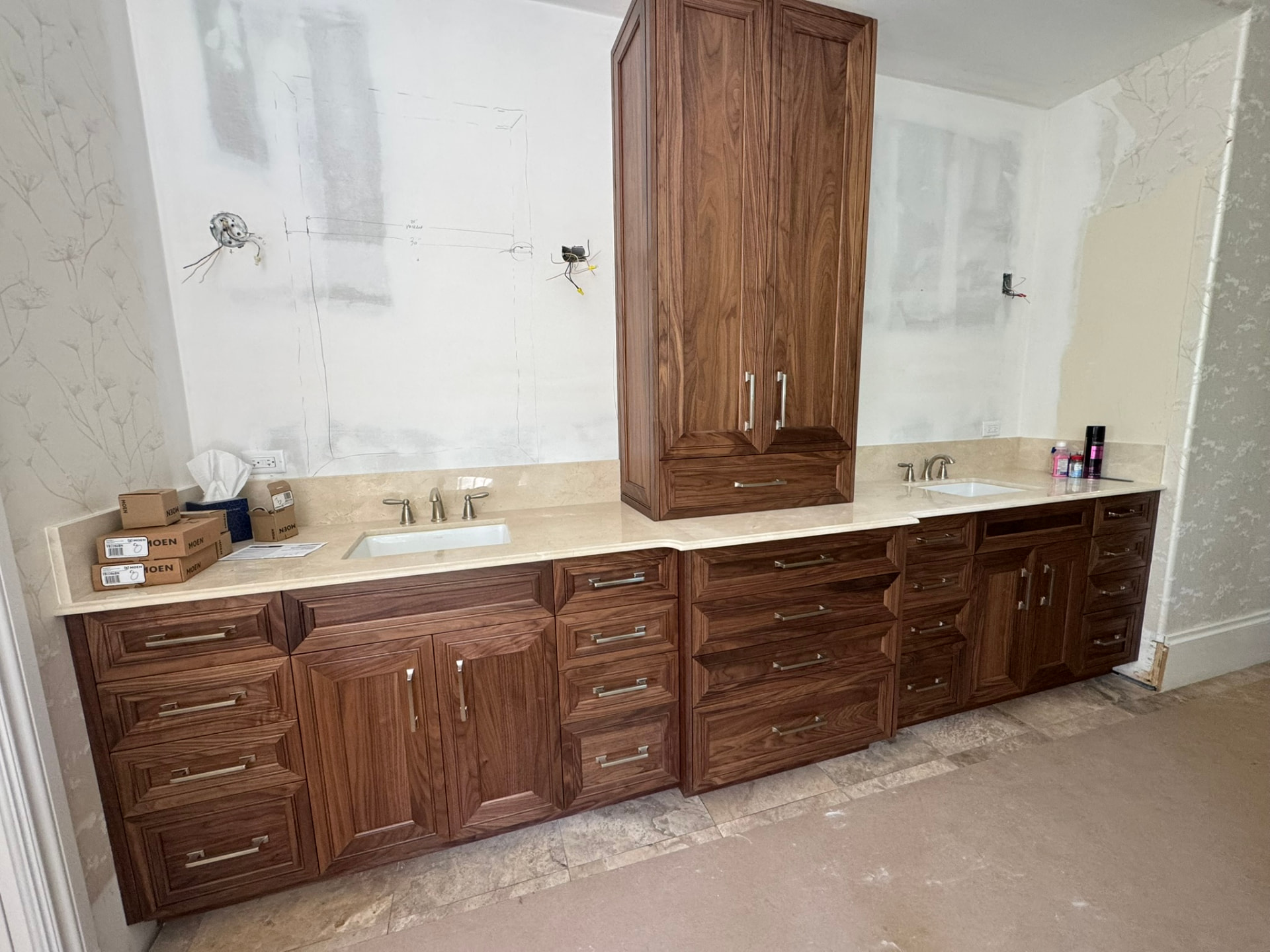 Custom walnut bathroom vanity run with two sinks, deep drawers, and a countertop bridge cabinet