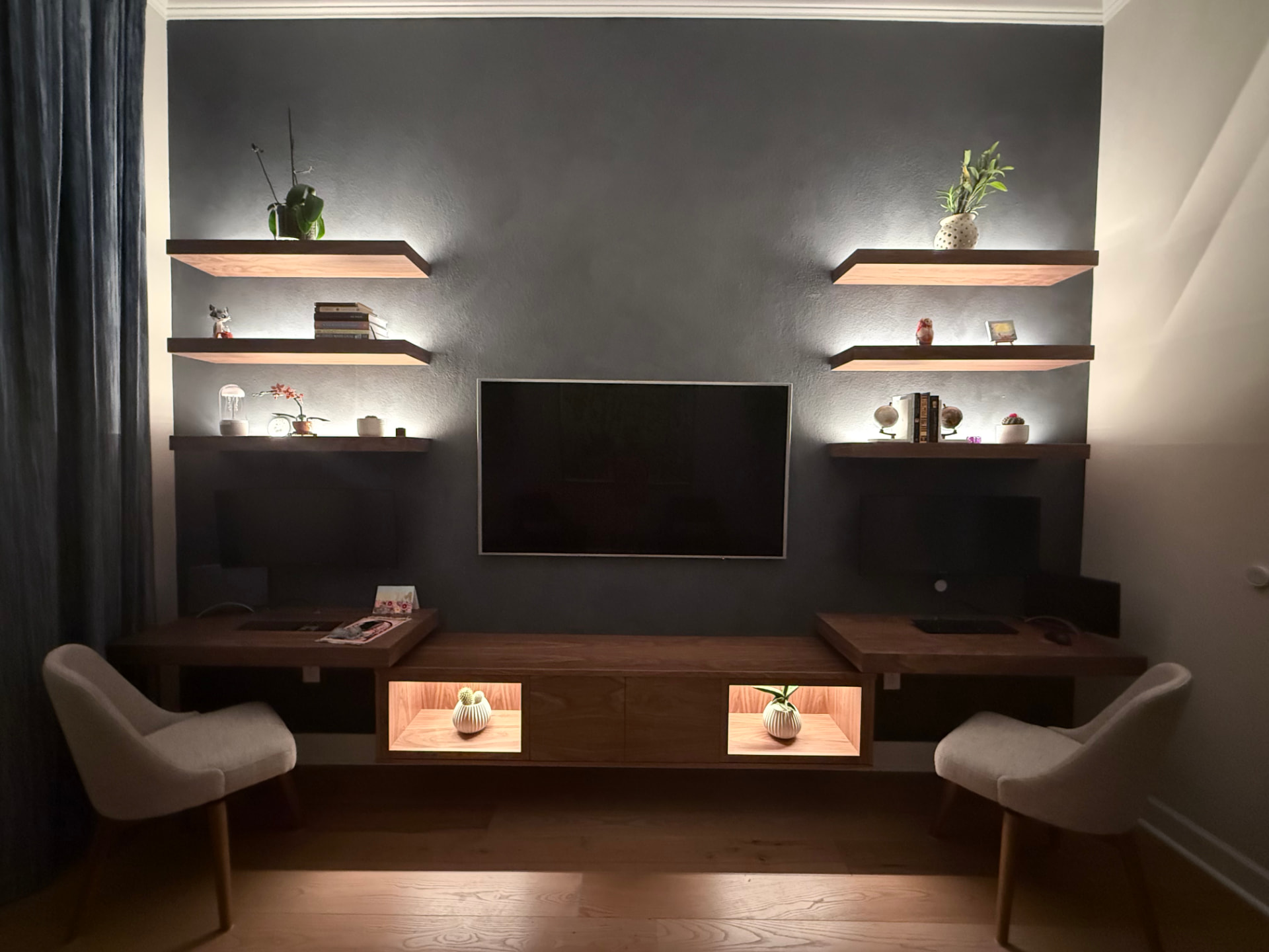 Evening view of the walnut entertainment center with warm shelf lighting