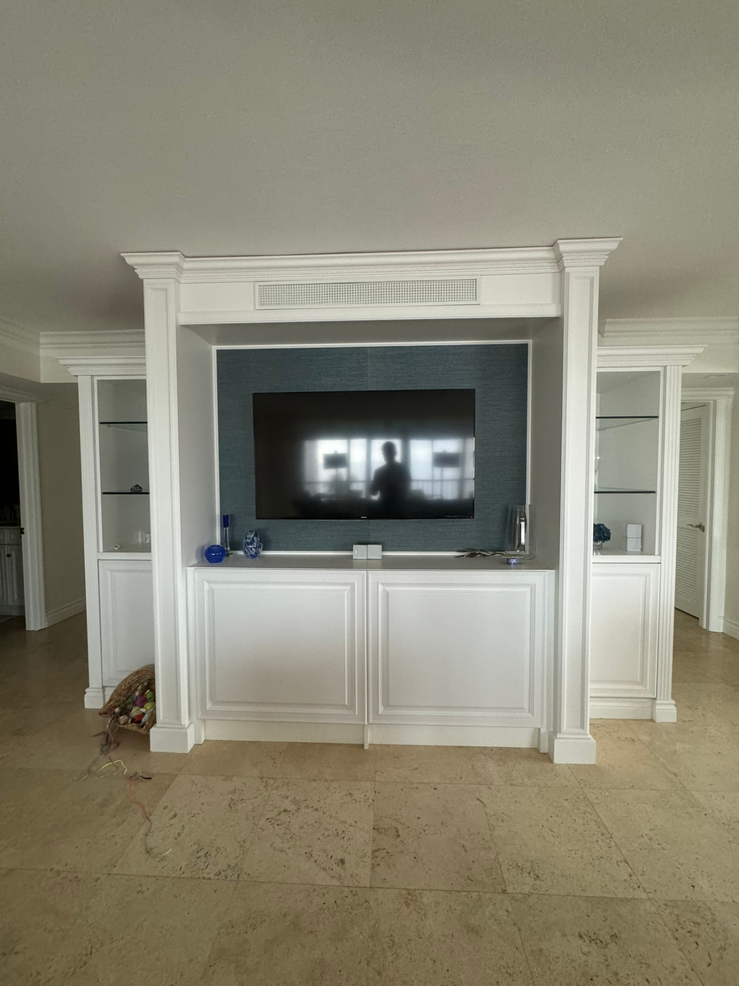 Custom white painted built-in entertainment center with media storage and display shelving in a Naples living room